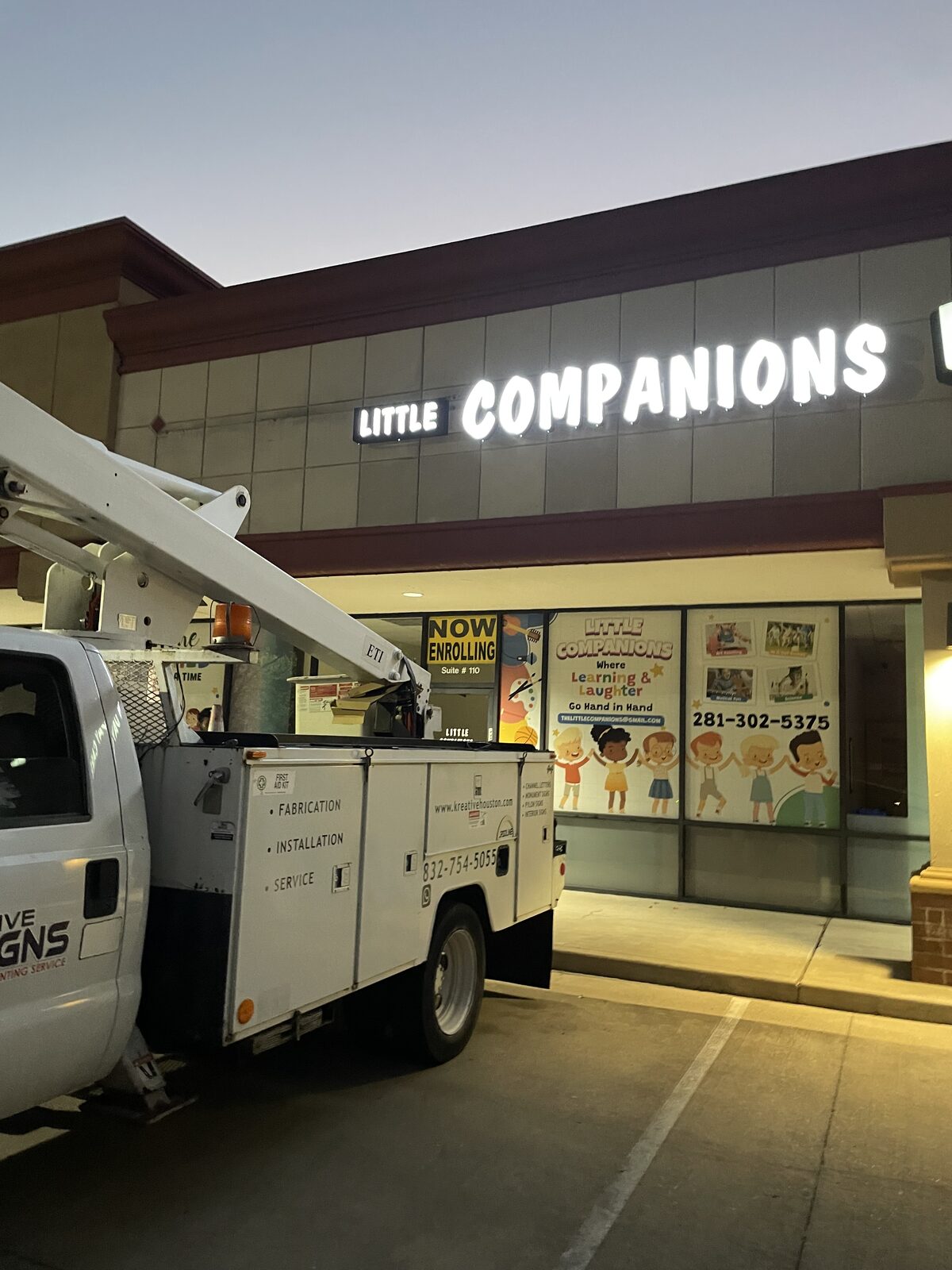 Little Companions illuminated channel letter and window graphics sign at night, Houston, TX